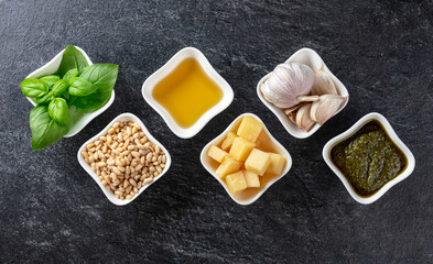 Traditional Italian pesto recipe on a dark stone background.
