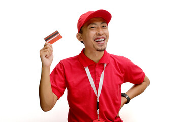 Excited Asian delivery man or courier smiles broadly while showing a credit card to the camera, isolated on a white background.