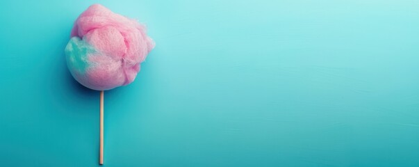 A pink cotton candy is on a blue background. Free copy space for text.