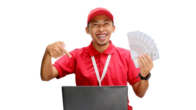 Asian delivery man, holding money while using a laptop against a white background. Concept of professionalism, e-commerce management, financial transactions, delivery services, and business efficiency