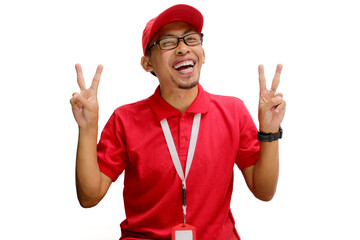 Attractive Asian delivery man or courier showing a peace gesture or V sign to the camera, isolated on a white background