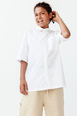 Cute young boy in stylish outfit striking a pose against a white backdrop for a trendy look