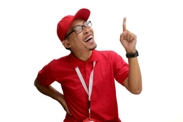 Naklejka premium Happy Asian delivery man or courier is captured in a eureka moment, pointing up with an excited expression as if having a revelation or brilliant idea. Isolated on a white background
