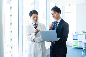 医師と打ち合わせするビジネスマン