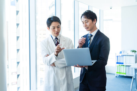 医師と打ち合わせするビジネスマン