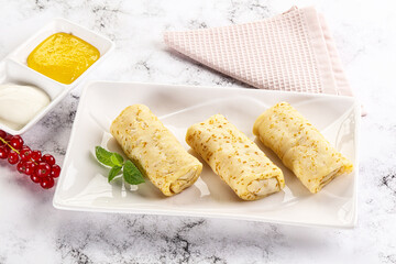 Homemade stuffed pancakes with honey and cream sour