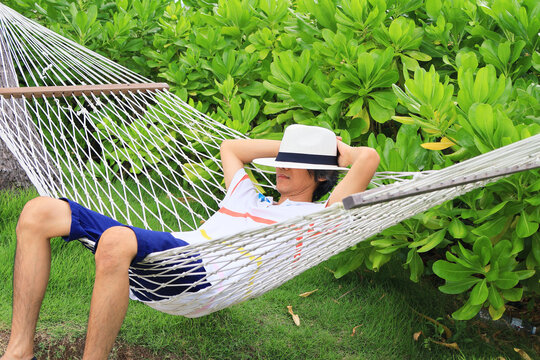 People taking a nap on the hammock in tropical garden