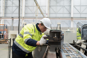 Male engineer repair and maintenance CNC machine in factory. Engineer maintenance machine at workplace. Engineer repair machine in line production