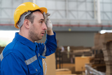 Tired male engineer worker working in factory in break time. Male worker working and wearing safety...