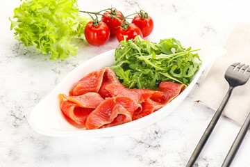 Sliced salmon with fresh arugula
