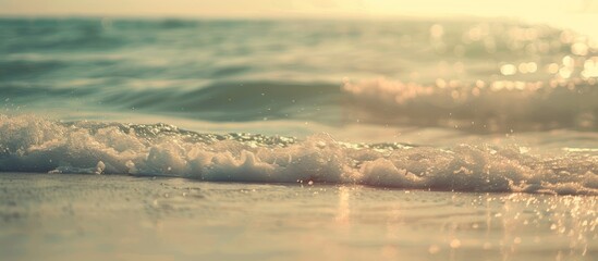 A blurry tropical beach with sunlit waves creates an abstract background for a summer vacation theme, featuring vintage tones and a relaxing atmosphere with copy space image.