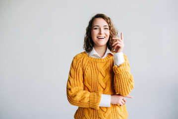 Young Woman Student Has Eureka Moment - Excited, Clever, Pointing Up with New Idea - Wow Promotion Offer Presentation - Conceptual Image of Innovation and Insight - Isolated on White Background