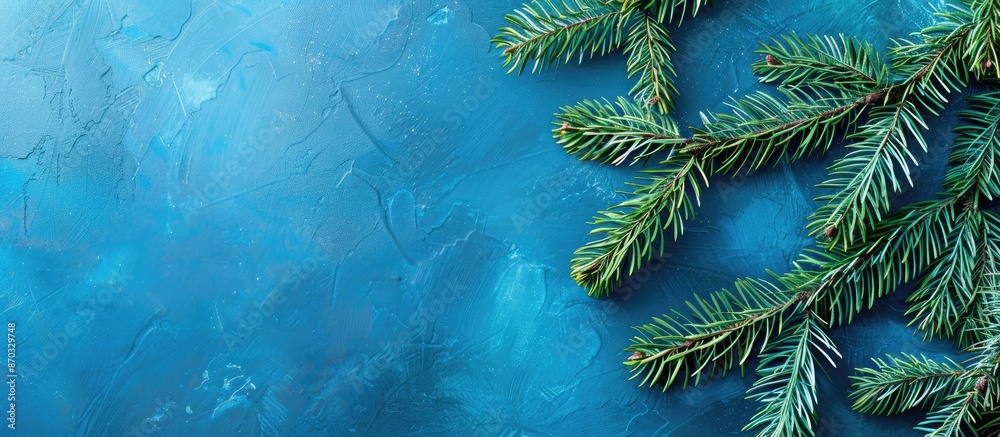 Poster a christmas-themed card featuring fir branches set against a blue backdrop with copy space image.