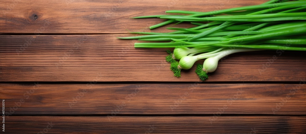 Poster Top-down view of vibrant green onion placed on a wooden table with space for a photo. with copy space image. Place for adding text or design