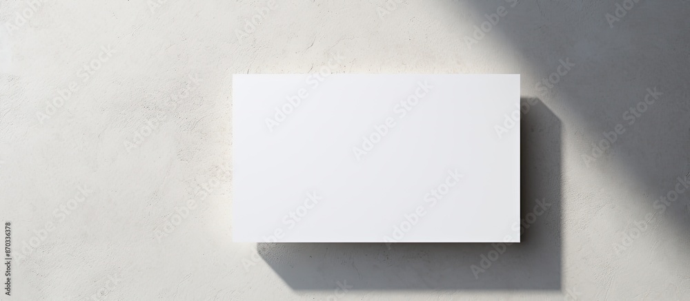 Poster Diagonal white business card mockups with soft shadows on a light grey concrete surface for a flat lay, top view with an open composition and copy space image.