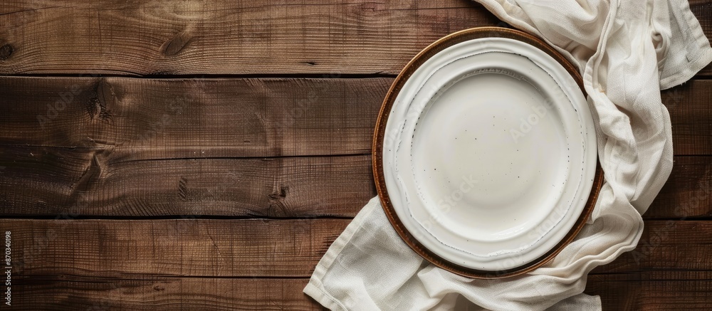 Leinwandbilder top view image of an empty plate and linen napkin set on a brown wooden background with ample copy s