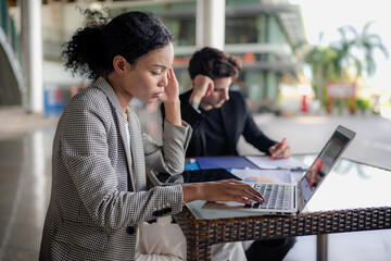 Latino man and African American businessperson brainstorming startup small business strategy together. Young multiracial businesswoman and colleague serious working on planning. Diversity people team.