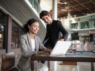 Latino man and African American businessperson brainstorming startup small business strategy together. Young multiracial businesswoman and colleague serious working on planning. Diversity people team.