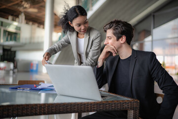 Latino man and African American businessperson brainstorming startup small business strategy together. Young multiracial businesswoman and colleague serious working on planning. Diversity people team.