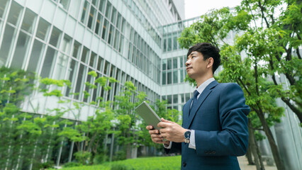Fototapeta premium Green Business, Environmental Growth and Sustainable Resource Business, Concept ESG Environmental, Social and Corporate Governance. Businessman Working on Tablet, Planning for Future.