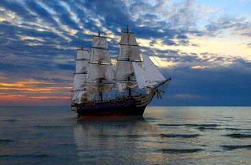 Old 18th century ship on calm ocean water at sunset