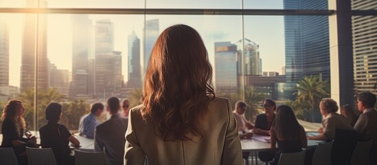 A woman presenter leads a tech business conference, discussing happiness, diversity, success, leadership, and productivity, shown in a back view shot with copy space image.