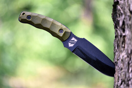 Ukraine, Kyiv. 20.06.2024. combat knife. the knife will stick in the tree. Azov emblem. black blade. tactical ammunition. Ukrainian stormtrooper knife. steel arms. sharp blade, close-up. editorial