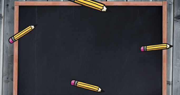 Image of pencils falling over black board with copy space - Powered by Adobe