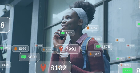 Image of social media networking icons over african american talking on smartphone outdoors