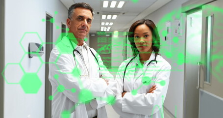 Image of codes, brain, molecules over diverse doctors with arms crossed standing in hospital