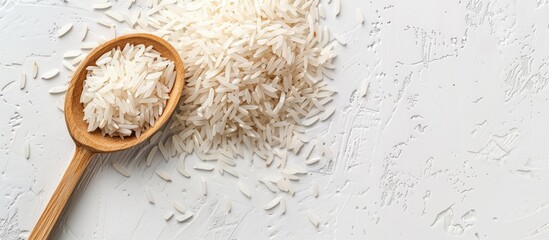 A scoop of long Basmati rice on a white background with copy space image. Vegetarian food concept, macro view, flat lay style.