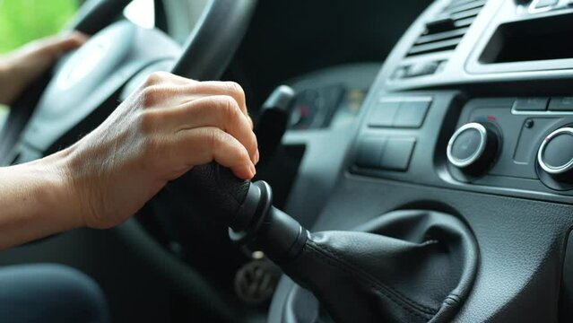 Close-up of driver change speed holding hand on gearbox car. Woman's hand at gearshift in car