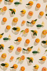 Top view juicy orange yellow tangerines as trend pattern minimal style, Natural citrus fruit with green leaf, light beige background. Organic, healthy, vegetarian and plant-based food, pastel tone