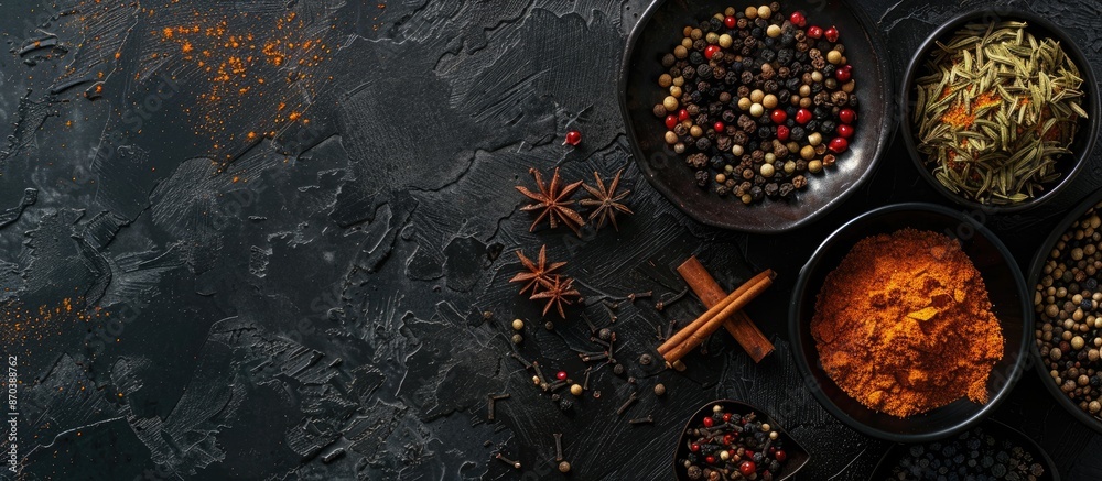 Poster Flat lay of various spices displayed on a dark concrete background with ample copy space image.