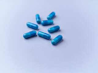 Amino acids capsules on bright paper background. Soft focus.