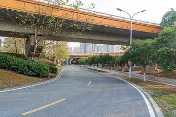 Naklejka premium Concrete structure and asphalt road space under the overpass in the city
