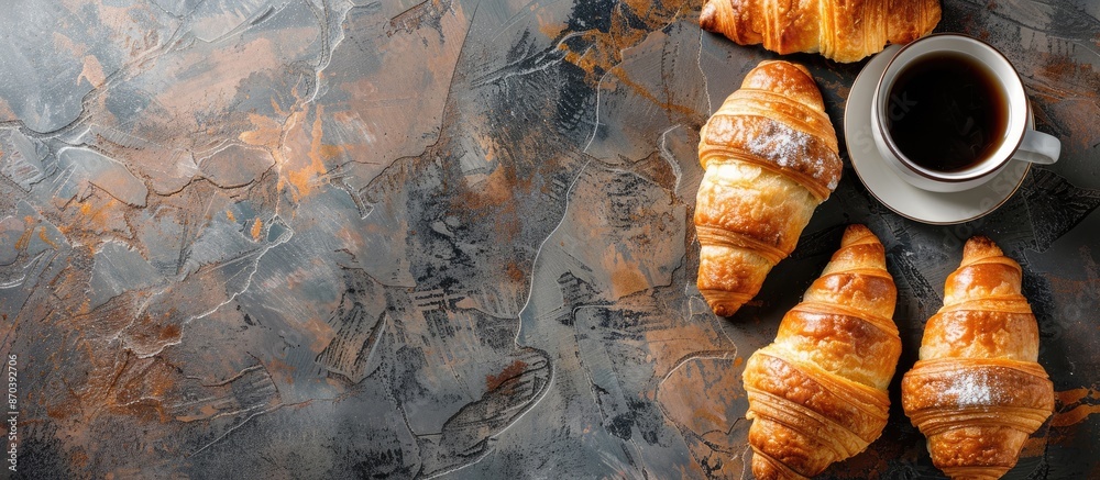 Poster Croissants and coffee displayed elegantly on a textured stone table with ample copy space image.