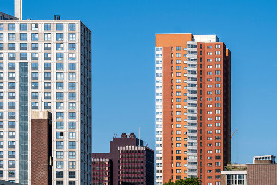 Photo featuring modern high-rise buildings with varying architectural styles, captured against a clear blue sky, highlighting urban development and city life in Rotterdam