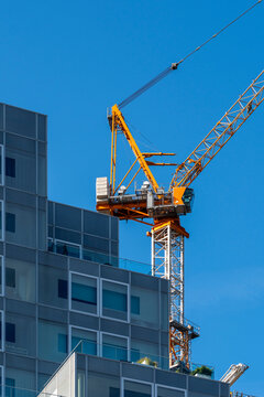 Photo capturing an active construction crane working on a modern urban building, signifying growth, development, and the continuous expansion of urban landscapes in Rotterdam