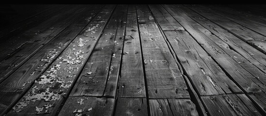 An aged wooden floor with peeling paint creates a dark vignette backdrop in a black and white image with copy space.