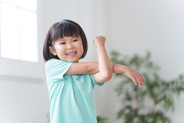 家で準備体操する子供（運動・スポーツ・ストレッチ）