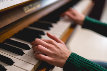 Fototapeta premium Close up shot of girl hands playing piano