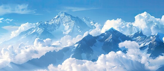 A gorgeous panoramic mountain view with snow-capped peaks peeking through fluffy white clouds under a clear blue sky on a sunny day, with room for text or other graphics in the image