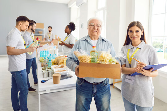 Senior help, young volunteer group working in charitable food foundation, make donation to old needy. Charity food bank, separating donations stuff, basic need provisions, free meal for elder in need