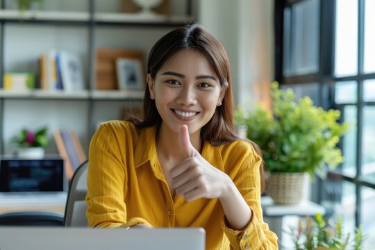 Woman using laptop  happy expression  thumbs up gesture.