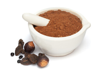 Close-up of Organic Reetha (Sapindus mukorossi) Amla (Phyllanthus emblica) and Shikakai (Acacia concinna) Powder with its Fruits, in white ceramic mortar and pestle, isolated on a white background.