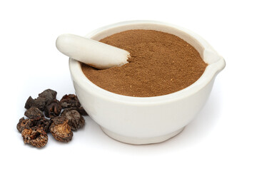 Close-up of Organic Dried gooseberry (Phyllanthus emblica) or Amla powder with fruits, in white ceramic mortar and pestle, isolated on a white background.