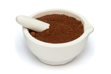 Close-up of Dry Organic Shikakai (Acacia concinna) powder, in white ceramic mortar and pestle, isolated on a white background