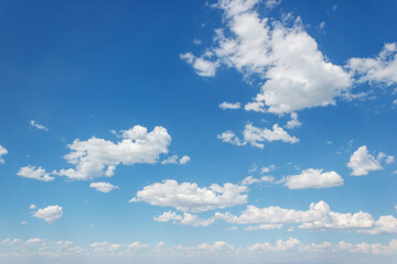 Blue summer sky with curly clouds stretching to the horizon.