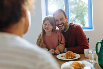 Father and daughter laughing during family breakfast